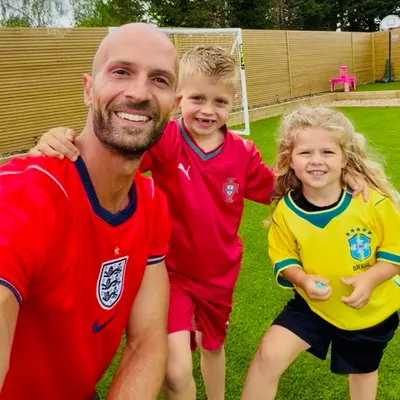 Daniel, Joshua and family in their football shirts in the garden