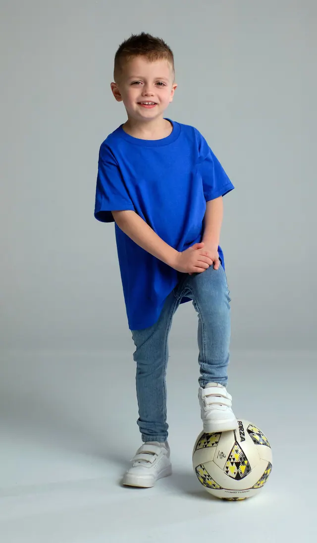 Joshua with his foot on a football